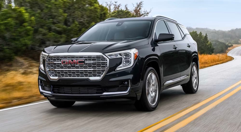 Black 2024 GMC Terrain Denali driving to a GMC dealer
