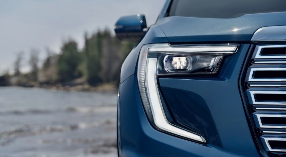 Headlight of a blue 2024 GMC Acadia Denali