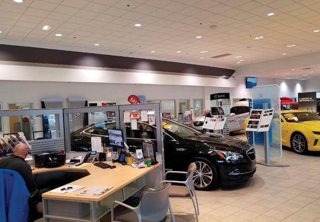 Multiple vehicles in a dealership showroom.