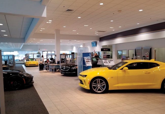 Multiple vehicles in a dealership showroom.