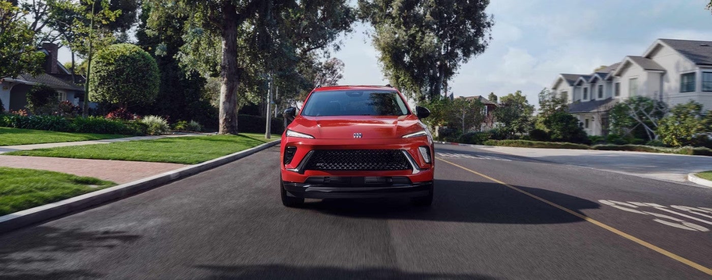 Red 2026 Buick Envision ST driving on a suburban street