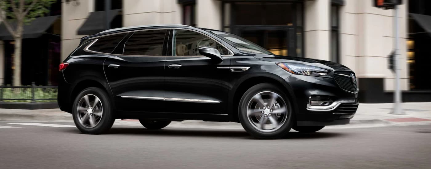 Black 2021 Buick Enclave driving through a city from a used Buick dealer near Richmond.
